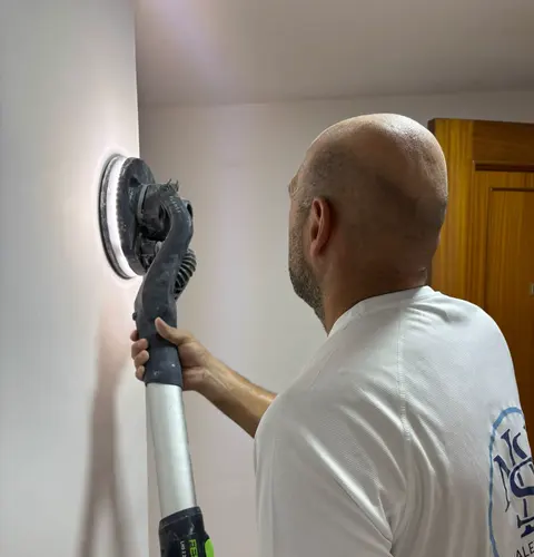 Profesional ejecutando acabado de yeso en pared interior